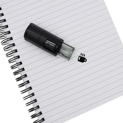 Self Inking Stamp Laying Flat On Note Pad With Coffee Cup Print